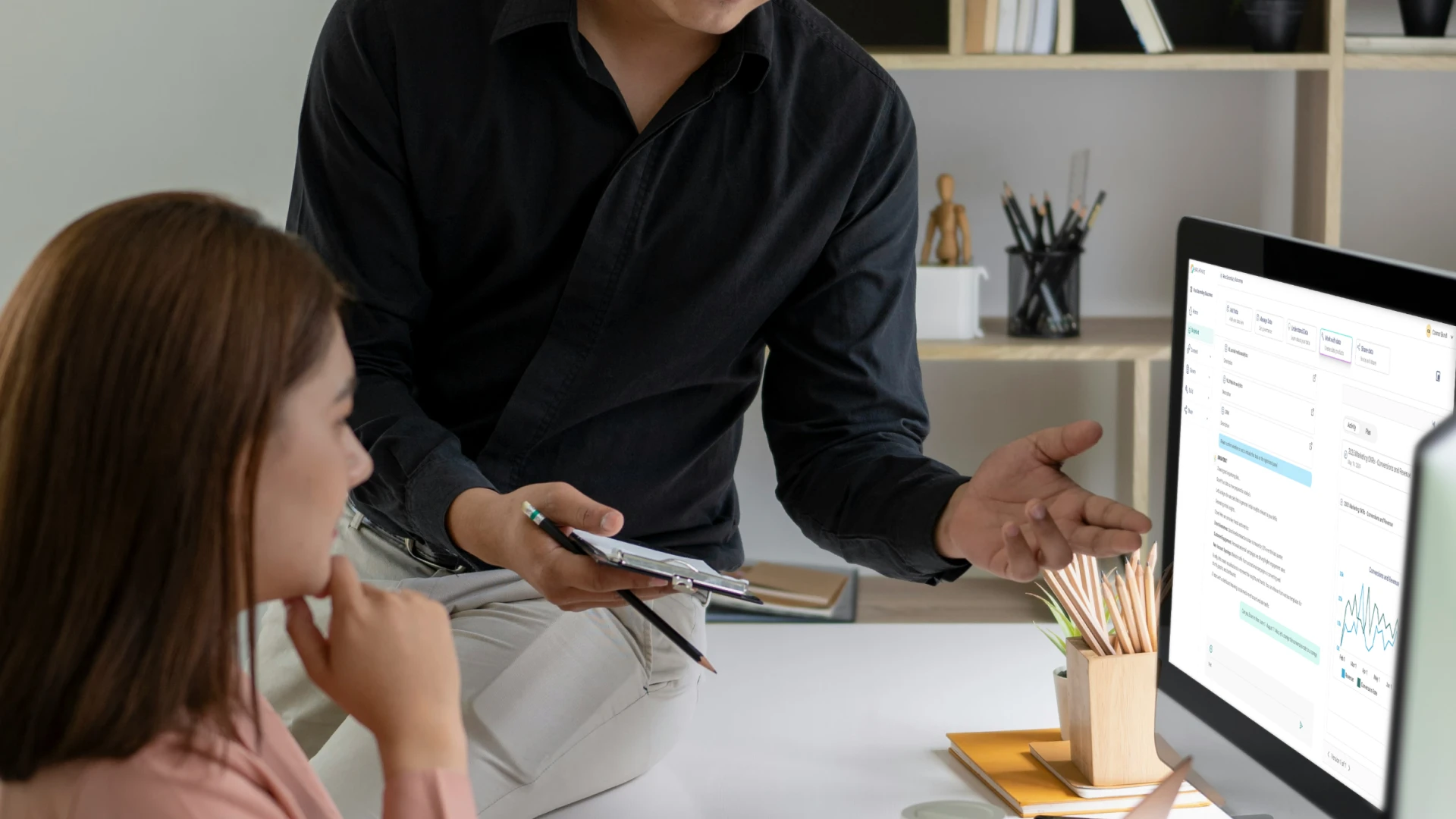 Two people discussing data displayed on BrightHive interface
